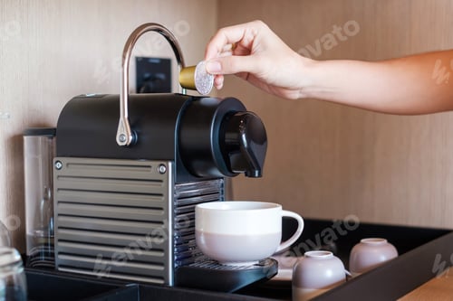 Preview: Hand making Espresso by Coffee Machine with capsules on wood table