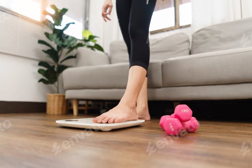 Preview: Healthy and weight loss concept, Young Asian woman stepping on weighing scales after weight control.