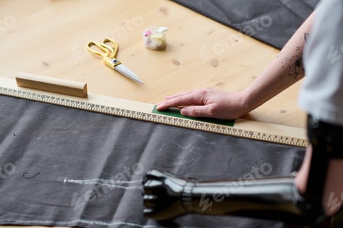 Preview: Arm prosthesis of young female tailor or fashion designer working with textile