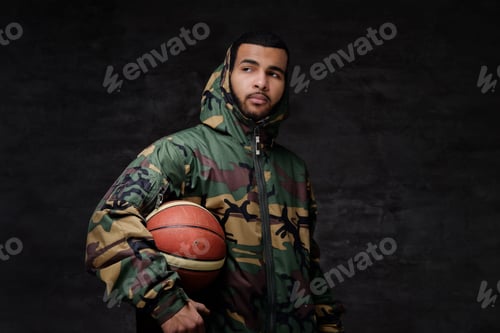 Preview: Portrait of a young African-American street basketball player in a camouflage jacket.