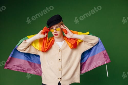 Preview: Studio photo of a man with rainbow flag isolated on green background