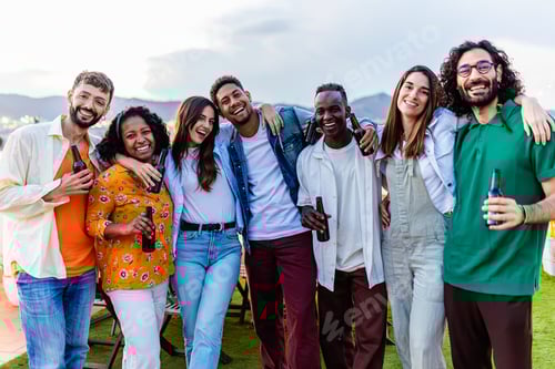 Preview: Group portrait of young diverse friends standing together at rooftop party