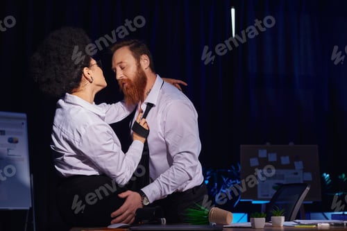 Preview: african american woman flirting with bearded tattooed colleague near mess on work desk in office