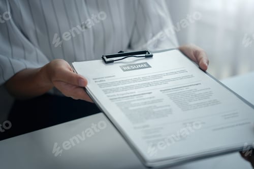 Preview: During the recruitment process, an hr manager is seen holding a resume on a clipboard