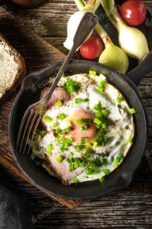 Preview: Fried eggs with ham on an old wooden background.