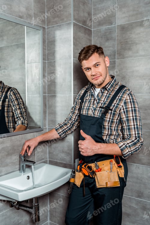 Preview: installer standing near faucet with flowing water and showing thumb up