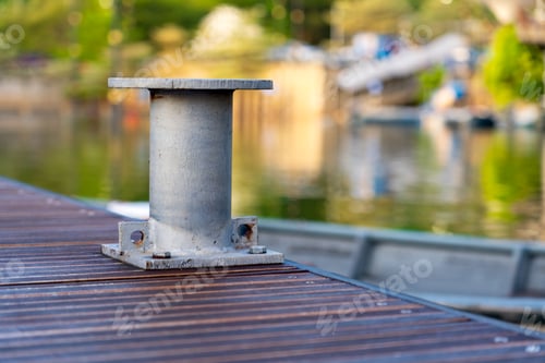 Preview: Metal Bollard on Wooden Dock with Rope Securely Wrapped, Fastening a Boat in a Rustic Marina Setting
