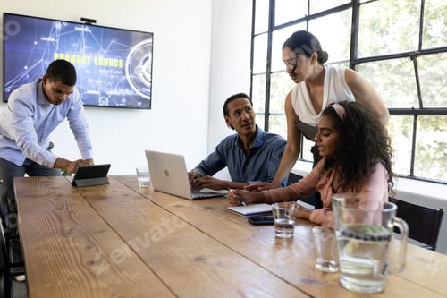 Preview: Diverse business team collaborating on project with laptops in modern office