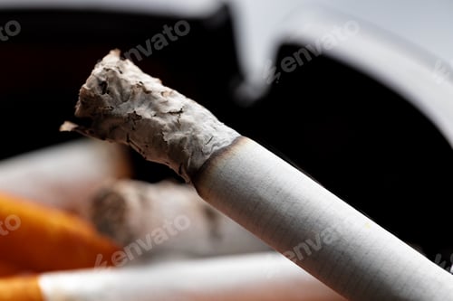 Preview: Burning cigarette in a black ash tray