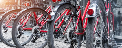 Preview: Closeup view many red city bikes parked in row at european city street rental parking sharing