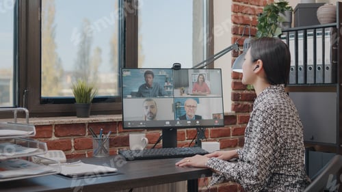 Preview: Business woman talking to colleagues on online video call
