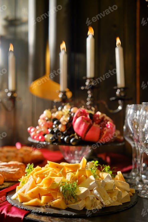Preview: An inviting cheese platter with fruits and candles set for a cozy evening gathering