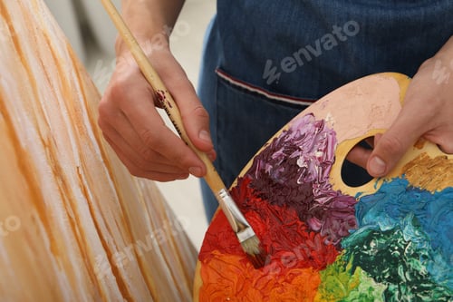 Preview: Man with palette and paintbrush drawing picture, closeup