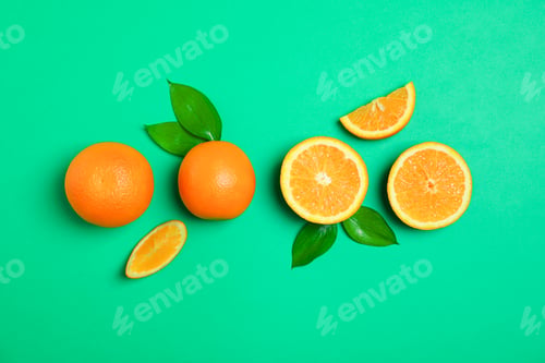 Preview: Flat lay composition with oranges and leaves on color background. Space for text