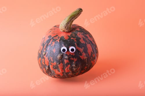 Preview: Funny pumpkin on orange background with eyes on it.Negative space for text.