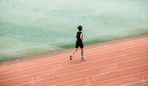 Preview: Young student doing long-distance running on a red university track in Wuhan.