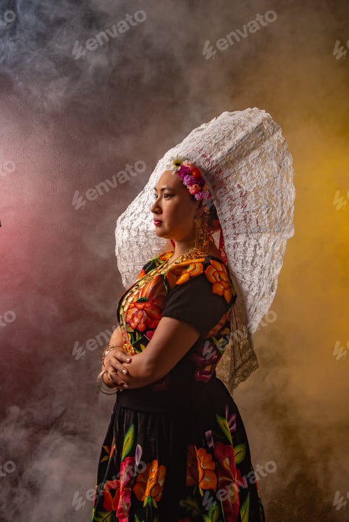 Vista previa: Una mujer con un vestido florido y un sombrero blanco se para frente a una pared