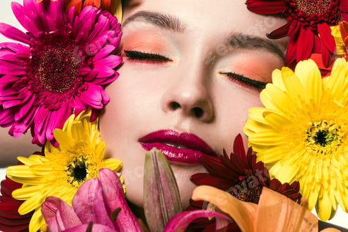 Preview: close-up portrait of beautiful young woman with closed eyes surrounded with various flowers