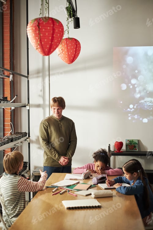 Preview: Caucasian Male Teacher Supervising Diverse Children Studying Together Indoors