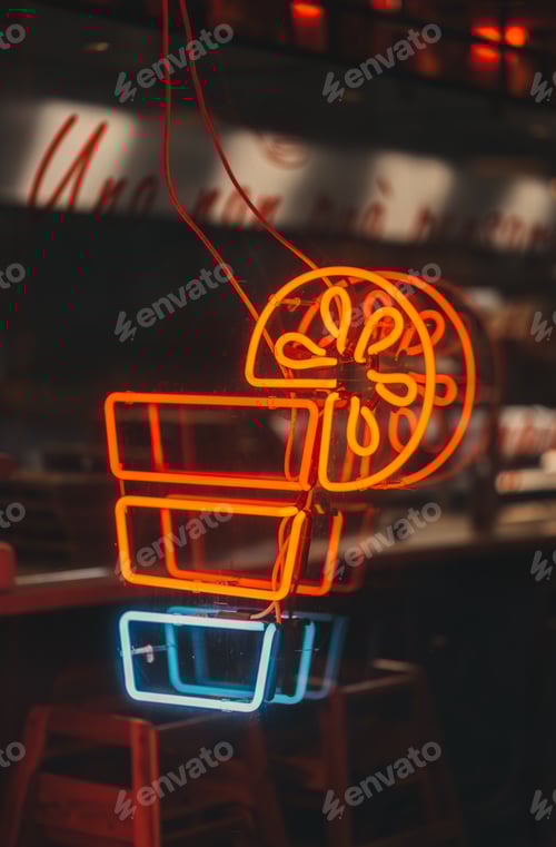 Preview: Vertical closeup shot of a neon light cocktail cup with a lemon slice on a cafe wall