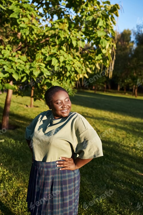 Preview: Empowered curves: woman stands strong in grass