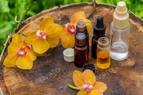 Visualização: garrafas com óleos essenciais e orquídea em tigela isolada no fundo branco