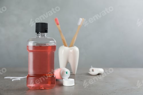 Preview: Mouthwash and other oral hygiene products on grey table, space for text