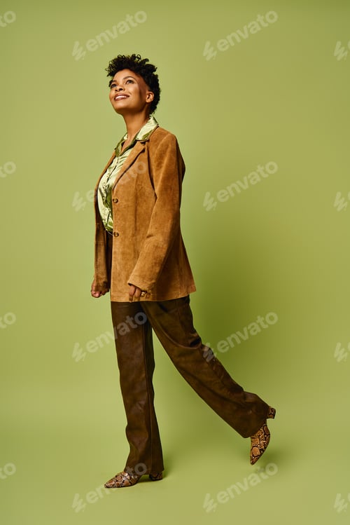 Preview: Stylish African American woman confidently showcasing modern fashion on a vibrant green backdrop