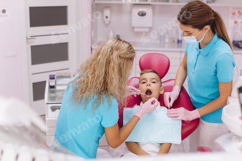 Preview: Woman dentist makes a dental examination of the boy mouth