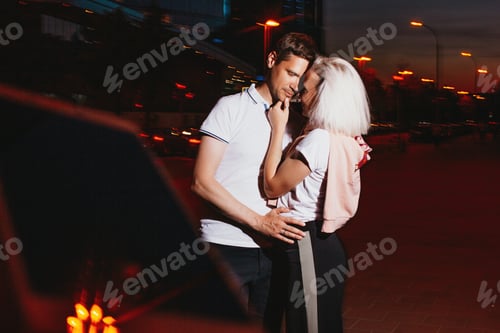 Preview: Young happy couple in love kissing in the night cuty street. Photo with flash effects