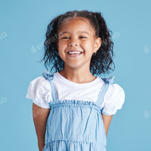 Preview: Portrait of happy smiling little girl against blue studio background. Cheerful mixed race kid in ca