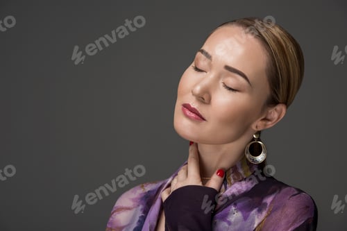 Preview: portrait of sensual kazakh woman with closed eyes posing isolated on grey