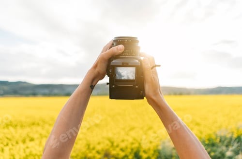 Preview: Male hands holding vintage camera in air