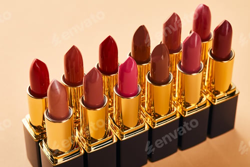 Preview: Close up of red shades of lipstick in tubes on beige