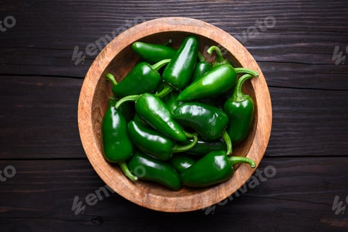 Preview: Top view on wooden bowl filled with green jalapeno peppers