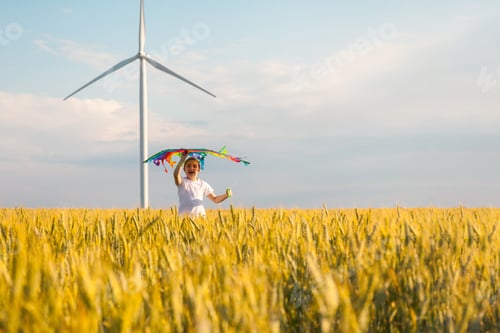 Preview: Happy Little girl running in a wheat field with a kite in the summer.