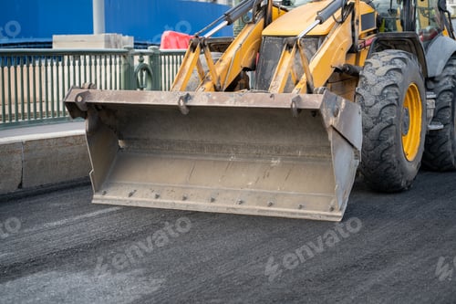 Preview: Repairing motor road with excavator with empty bucket driving on ground prepared for asphalt laying