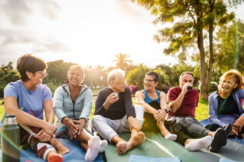 Preview: Happy multiracial senior friends drinking a tea after workout activities in a park