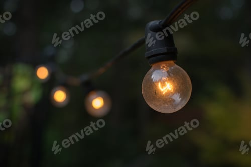 Preview: Closeup shot of an illuminated lightbulb hanging on a string