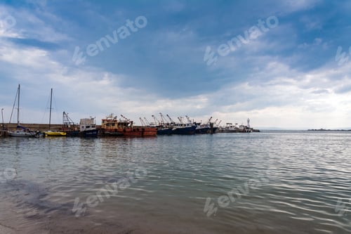 Preview: There is a lighthouse on the sea pier with boats.