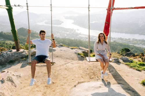 Preview: Young couple on a swing against a beautiful landscape