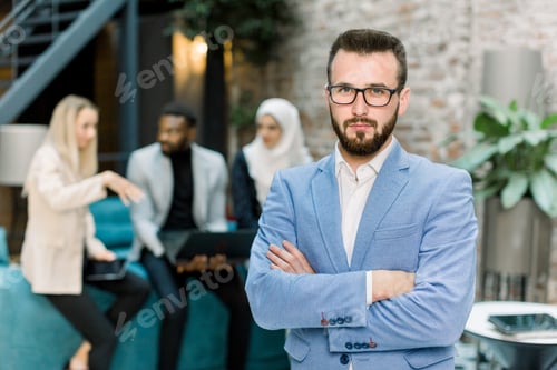 Preview: Pleasant smiling office worker, handsome bearded Caucasian man, posing on camera with arms crossed
