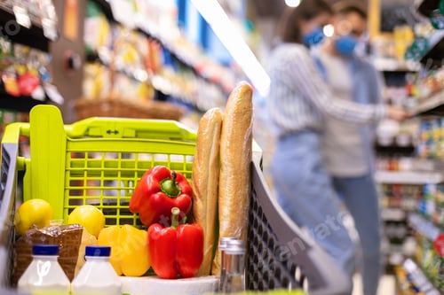Preview: Young couple in masks shopping in supermarket