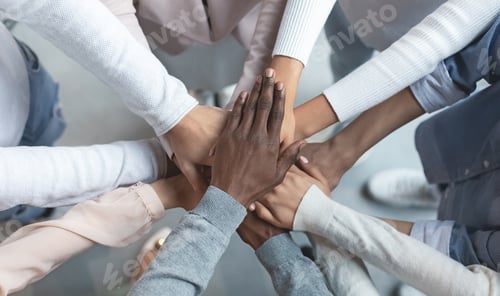 Preview: International business team putting hands together in cooperation