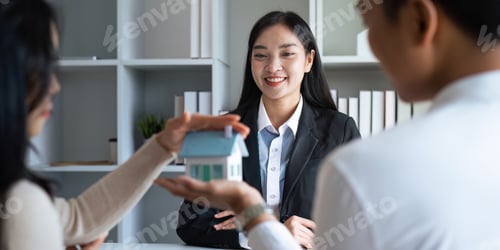Preview: Young Asian couple making contract with house sale agency. man and his wife sitting signing the