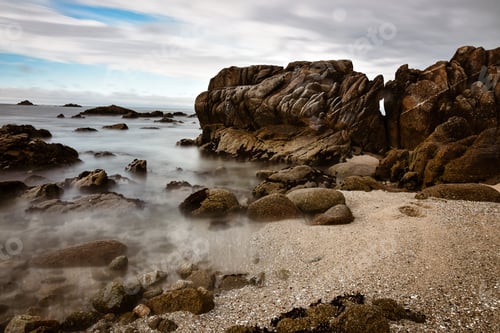 Preview: Long exposure of Pacific Ocean waves on rocky shoreline beach