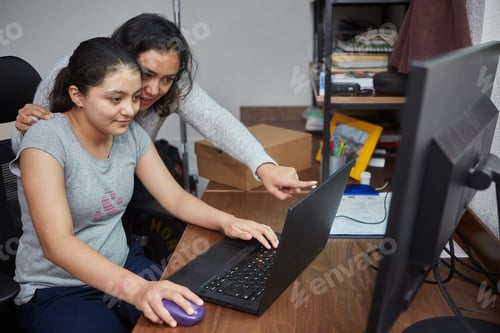 Preview: Mother helping her daughter to use the computer