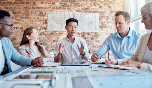 Preview: Group of diverse architects discussing plans, blueprints and schematics during a meeting in their o
