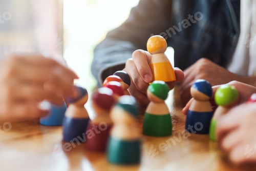 Preview: People choosing and picking up wooden figure from a group on the table