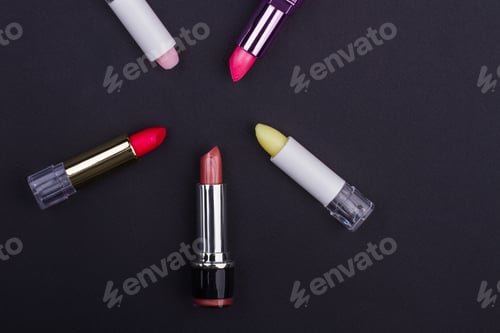 Preview: Set of bright multicolored lipsticks on black background.